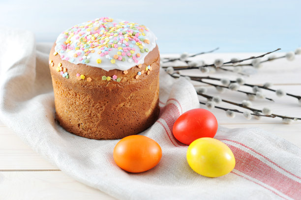 餐巾布上的复活节蛋糕。鸡蛋的周围是红色、黄色和橙色。在柳枝的框架里。图片下载