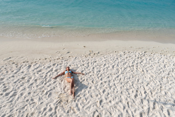 人间天堂——女孩躺在天堂岛的白色沙滩上。图片下载