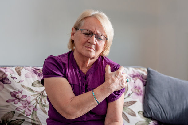 在家忍受肩膀疼痛的老年妇女。资深女士正在展示她的肩膀疼痛图片下载