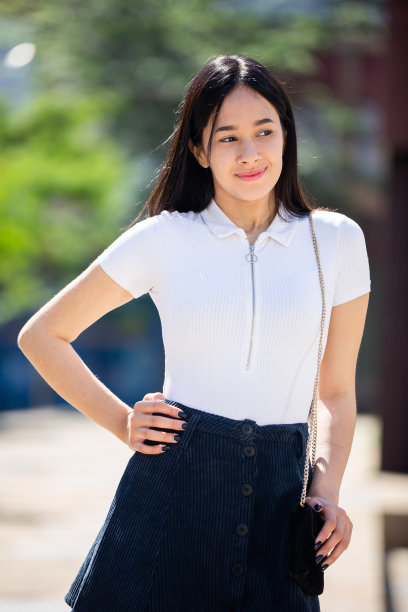 年轻女孩的肖像，穿着轻薄的裙子走过市中心的街道图片下载