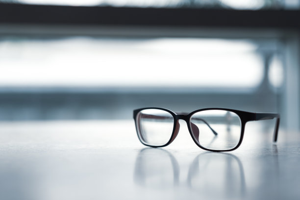 木桌上放着一副经典的粉色眼镜。图片下载