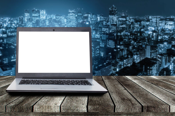 笔记本电脑笔记本电脑桌上的白色空白屏幕，以现代都市夜景为背景，广告，工作站，互联网技术，在线社交媒体，搜索数据概念图片下载