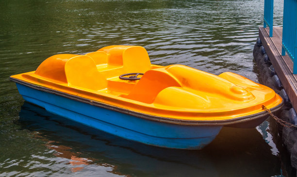 黄色双体船，以脚踏船的形式停泊在码头上图片下载