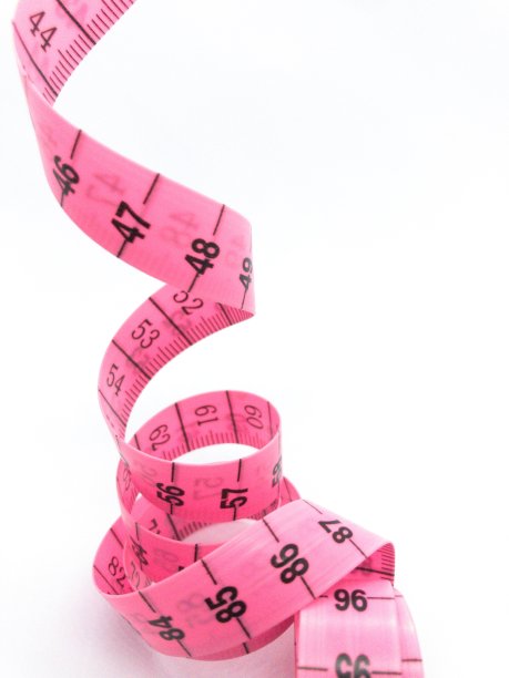 玫瑰和黑色卷尺隔离在白色上。图片下载