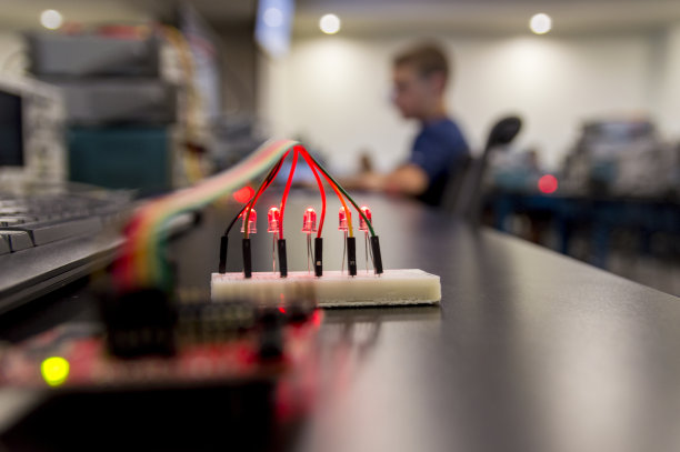 原型电路板上的亮红色发光二极管与微控制器相连图片下载