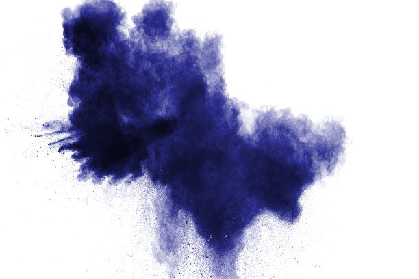 在白色背景上冻结蓝色尘埃爆炸的运动。在黑暗的背景下乱扔蓝色的粉末。图片下载