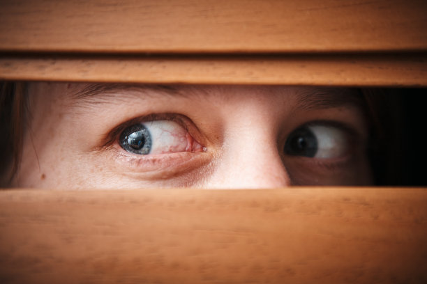 近距离的可怕的女性眼睛窥视通过威尼斯盲图片下载