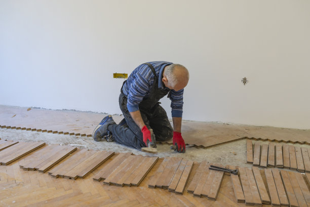 经验丰富的木匠正在通过更换地板来翻新房子图片下载