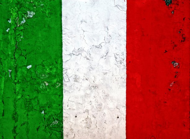 剥皮风化的墙上画着意大利国旗。图片下载