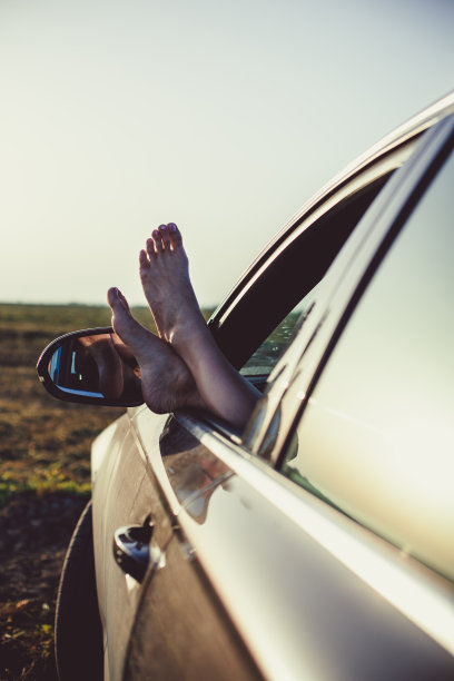 一个年轻女人的脚伸出了车窗图片下载