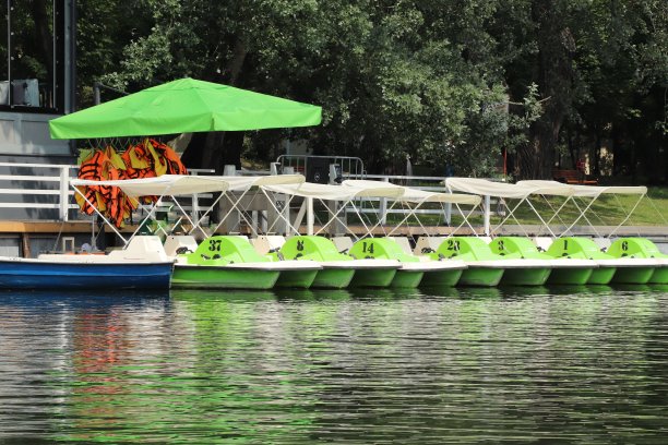 用脚踏在池塘上排成一排的小船图片下载