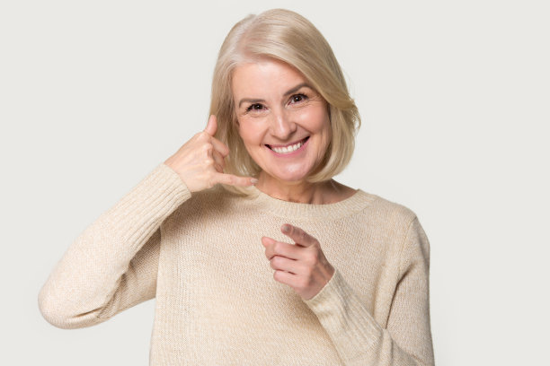 老妇人在灰色背景上显示呼叫信号图片下载