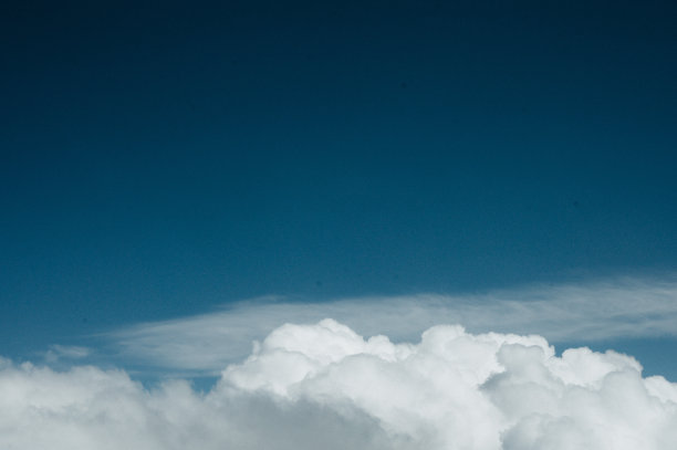 从飞机窗口看到的云层上的日出。从飞机窗口拍摄的云端照片的顶视图图片下载