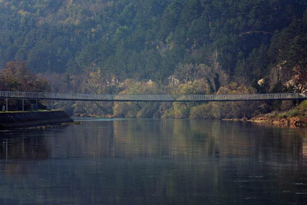 美丽多彩的秋水/一座横跨在河上的木桥，在美丽的绿色森林景色中。——图片图片下载