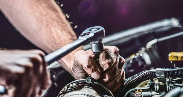 汽车修理工在汽车修理厂修理汽车发动机。维修服务。真实的特写镜头图片下载