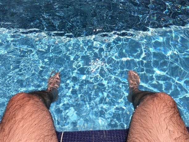 男人的脚浸在游泳池里图片下载