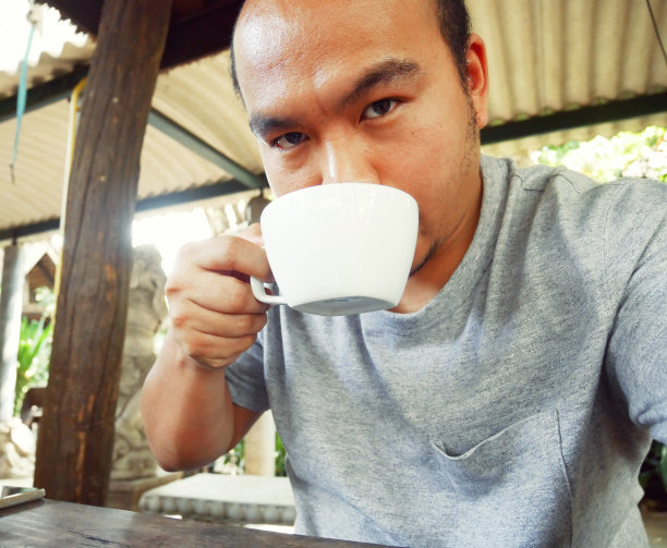 特写帅哥自拍和喝咖啡在早上。图片下载