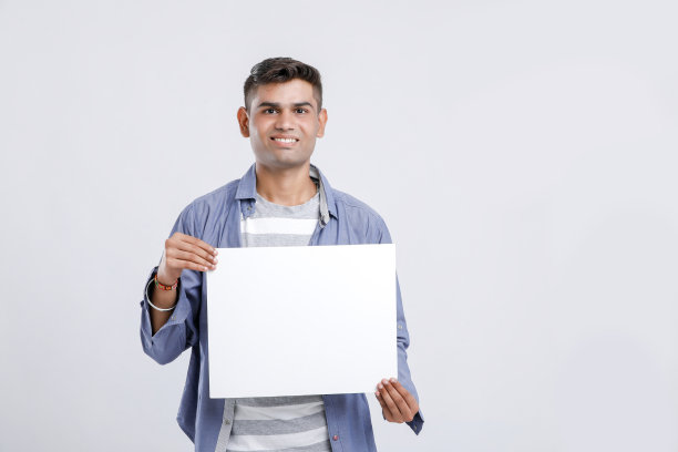 年轻的印度大学生在白色背景上展示空白的标牌图片下载
