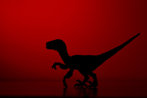 红色背景上的恐龙剪影。图片下载