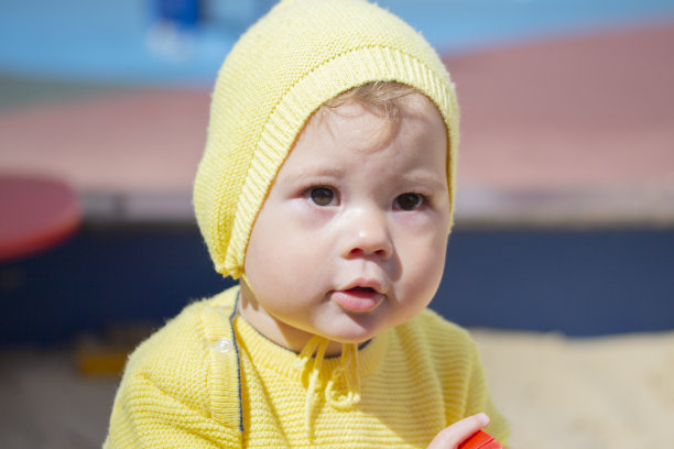 孩子走路的肖像，特写脸。男婴11个月大，穿着黄色针织衣服图片下载