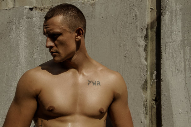 英俊的运动肌肉美丽的条纹男模特在牛仔布和白色衬衫在田径运动的背景图片下载