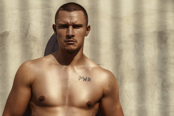 英俊的运动肌肉美丽的条纹男模特在牛仔布和白色衬衫在田径运动的背景图片下载