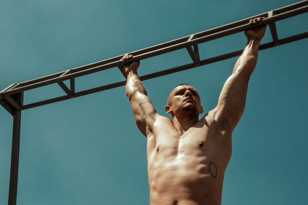 英俊的运动肌肉美丽的条纹男模特在牛仔布和白色衬衫在田径运动的背景图片下载