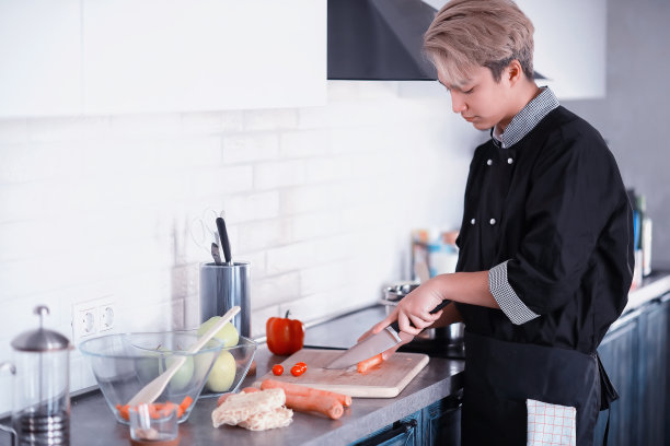 亚洲厨师在厨房准备食物在厨师服图片下载