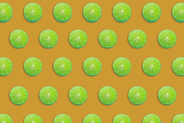 鲜绿的酸橙片上点缀着五颜六色的水果图案，俯视食物背景，平铺图片下载