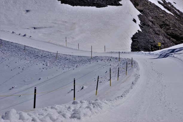 即使在盛夏，瑞士中部10,000英尺高的铁力斯山(Mount Titlis)山顶的山道也会越过雪原和冰盖图片下载