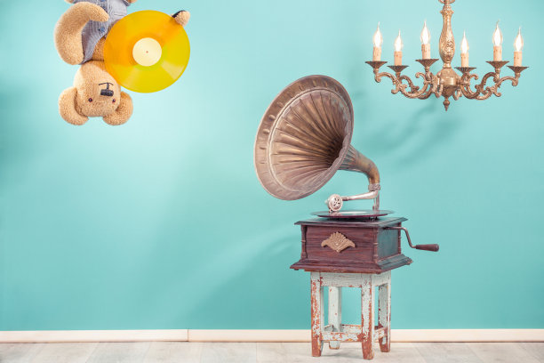 复古泰迪熊玩具垂下它的头与LP乙烯基在爪子，古董留声机留声机，旧青铜吊灯前蓝色背景。怀旧音乐的概念。复古风格滤镜照片图片下载