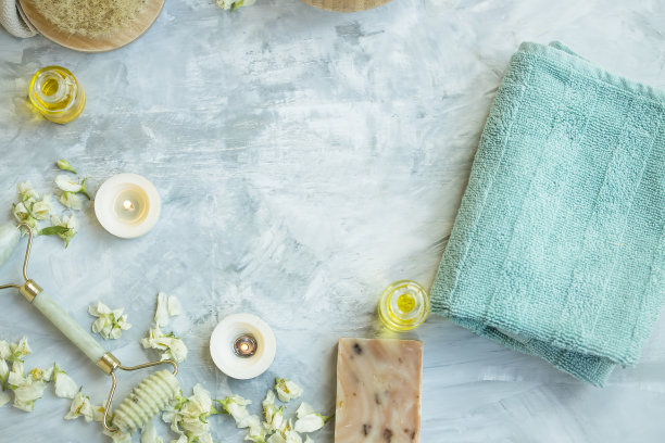 水疗静物顶景设置毛巾，蜡烛。茉莉花，玉面滚轮，身体油瓶在混凝土背景与复制空间，自然水疗背景图片下载