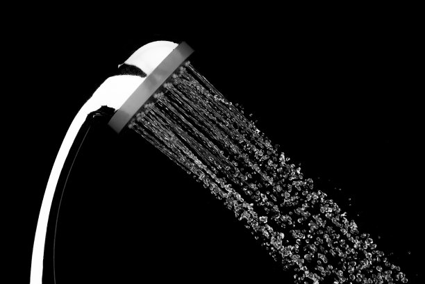 在黑色背景下，水滴从浴室淋浴喷头流出，停止运动图片下载