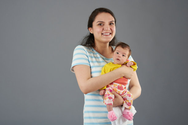 微笑着快乐的年轻妈妈图片下载