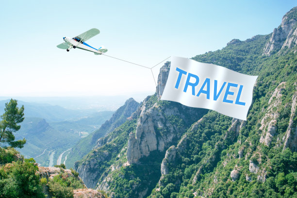 小飞机拉着横幅在空中旅行。图片下载