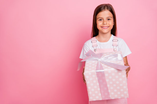 特写照片的小女士手拿大礼物盒圣诞假期周末穿整体孤立的粉色背景图片下载