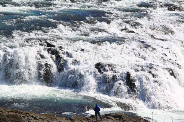 大自然的力量:当一个人面对冰岛壮观的海湾瀑布时图片下载