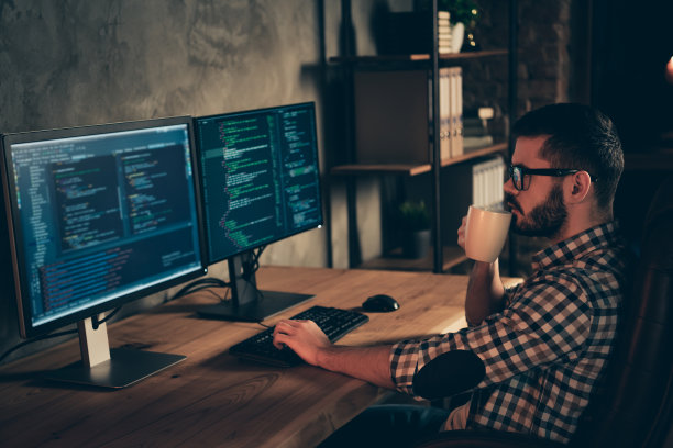 近距离的侧面资料照片帅气的杯子热的饮料他他他的家伙编码者打字php css键盘开发外包IT处理两个监视器桌子办公室代理穿规格正装衬衫图片下载