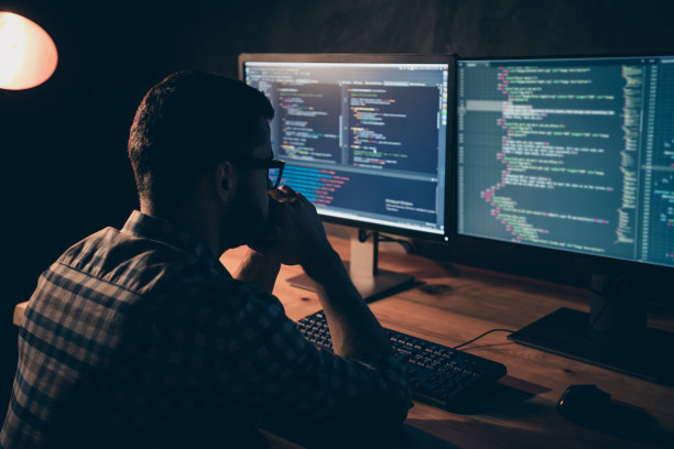 近距离的侧面资料照片帅气的他他他的家伙沉思沉思的手手臂下巴编码代码开发外包IT处理两个显示器桌子办公室穿着specs正式的格子衬衫图片下载