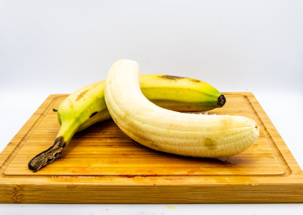 彩色的黄色和白色的香蕉在木砧板上。卡尔加里,加拿大阿尔伯塔省图片下载