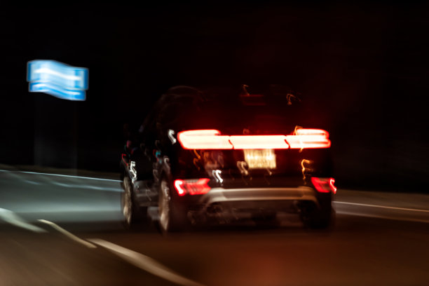 抽象特写的一辆车在黑暗的夜晚移动，傍晚五颜六色的颜色，路灯，红色的刹车形状图片下载