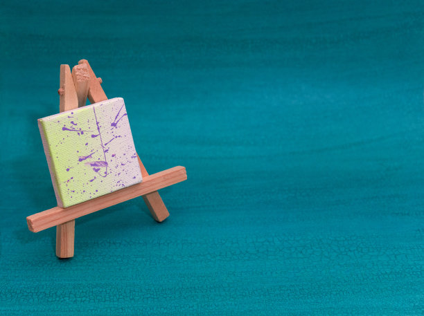 木画架或艺术工作板与绘制的帆布在绿松石背景与复制空间图片下载
