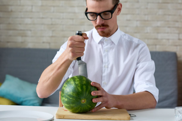 专注的人切成熟的西瓜图片下载