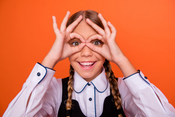 她的特写肖像，她很好，有吸引力，可爱的，愉快的，愉快的，高兴的，愚蠢的喜剧十岁前的女孩显示双两个ok-sign像眼镜孤立在明亮生动的亮橙色背景图片下载