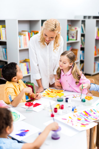 选择性的关注快乐的老师看着非裔美国孩子在纸上画画图片下载