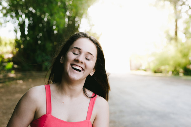 一个在户外微笑的年轻女人的肖像图片下载