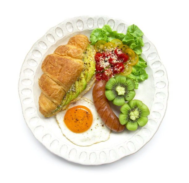 早餐套餐以牛角包内的牛油果沙拉黑胡椒、煎蛋、香肠、番茄沙拉上的雕花芝麻、新鲜猕猴桃雕花风格的菜肴为健康饮食食物融合吃每日俯览图片下载