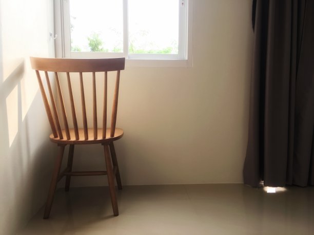 房间角落靠窗的木椅，早晨有阳光照射。图片下载
