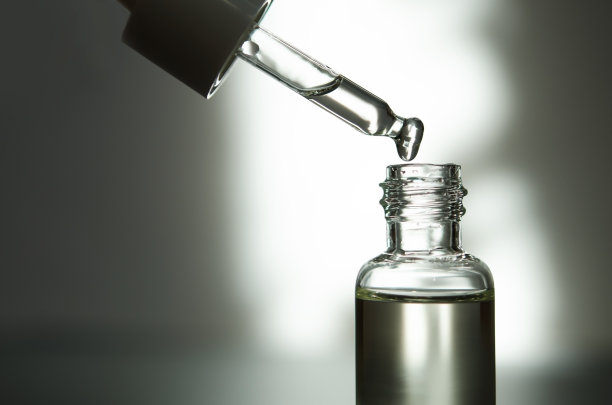 化妆或医疗用的带吸管的玻璃瓶。皮肤护理的概念。自然光硬，阴影深。——图片图片下载