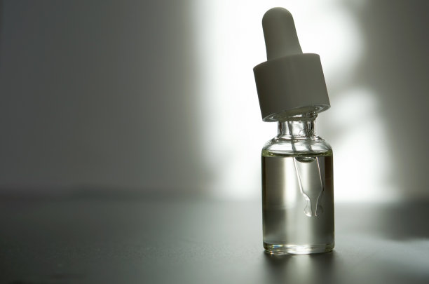 化妆或医疗用的带吸管的玻璃瓶。皮肤护理的概念。自然光硬，阴影深。——图片图片下载